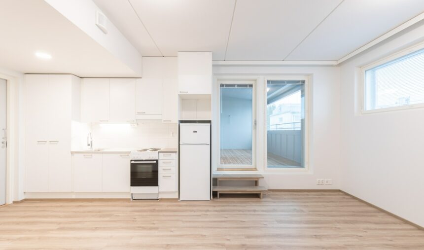 Kuva asunnosta jossa näkyy keittiö ja parvekkeen ovi.